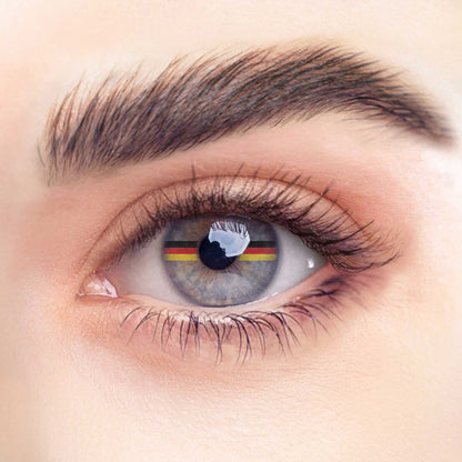 Rehlein Premium Beauty Linsen in der "Germany"-Edition. Transparente Monatslinsen ohne Sehstärke mit Flaggenmotiv. Kontaktlinsen mit dekorativer Deutschlandflagge für den täglichen Gebrauch. Nahaufnahme am Auge.